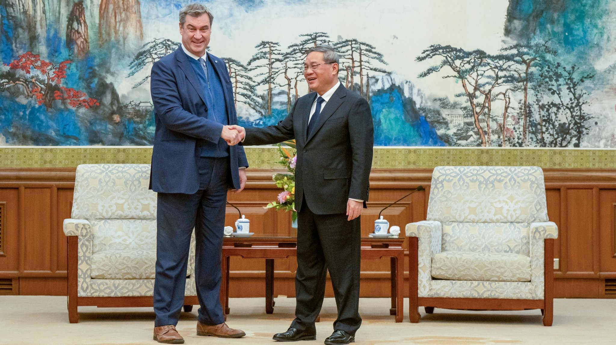 Markus Söder, (l, CSU) Ministerpräsident von Bayern, wird in Peking von LI Qiang (r), Premierminister der Volksrepublik China, empfangen. Söder bereist bis zum 28.03.2024 die Volksrepublik China.