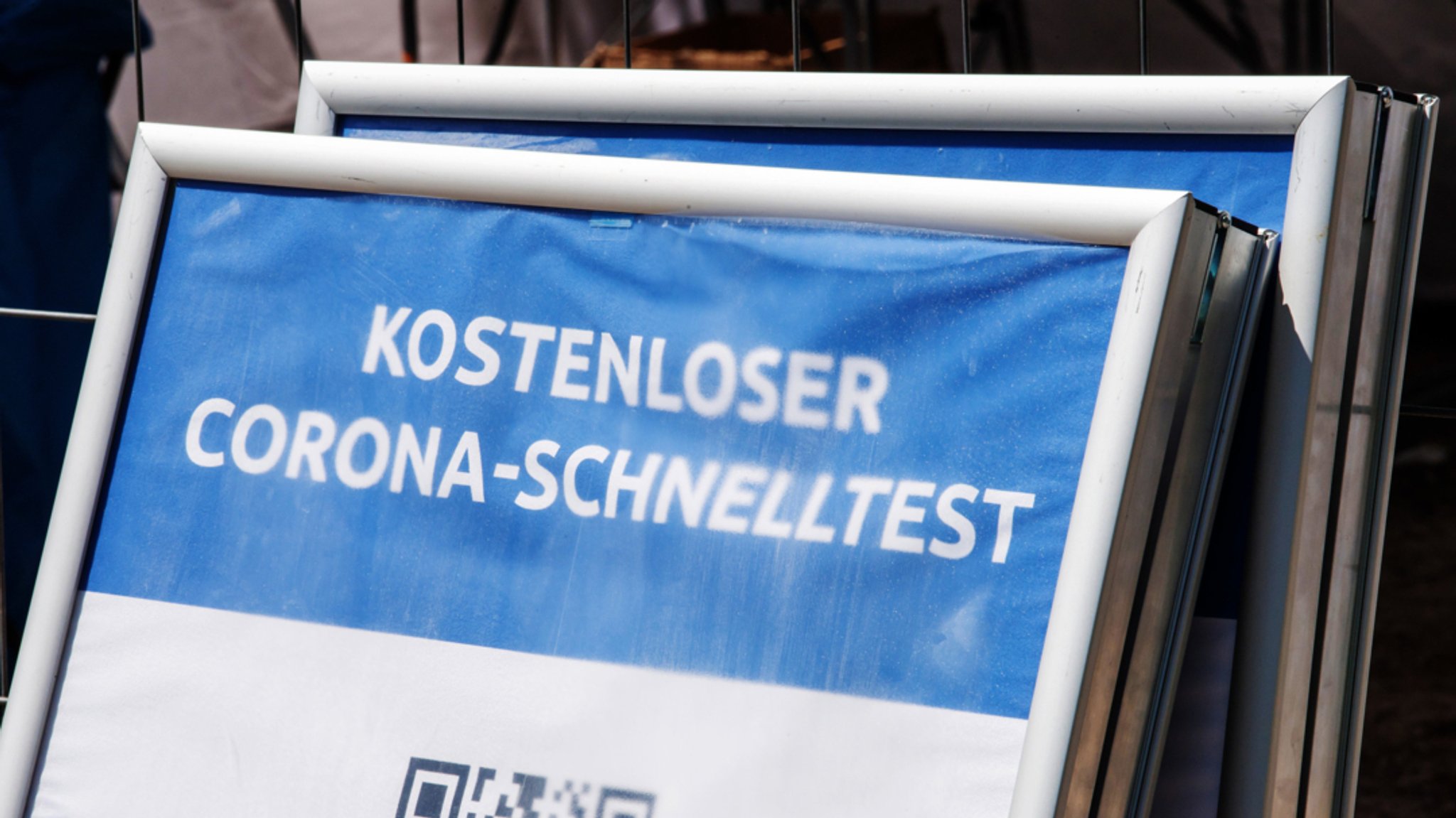 Ein Schild mit der Aufschrift "Kostenloser Corona-Schnelltest" steht vor einem Testzentrum.