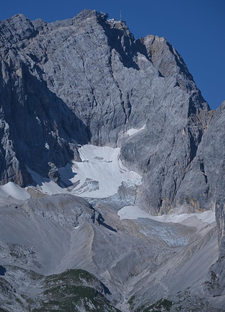 Ein Schneefeld auf grauen Felsen - die Reste des Höllentalferners unterhalb der Zugspitze 
