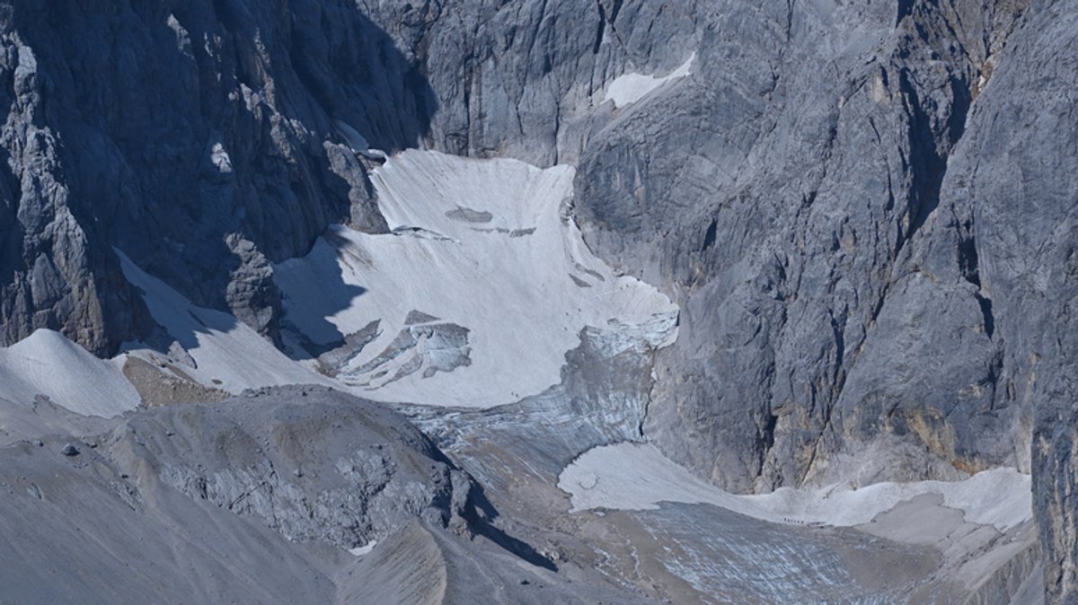 Ein Schneefeld auf grauen Felsen - die Reste des Höllentalferners unterhalb der Zugspitze 