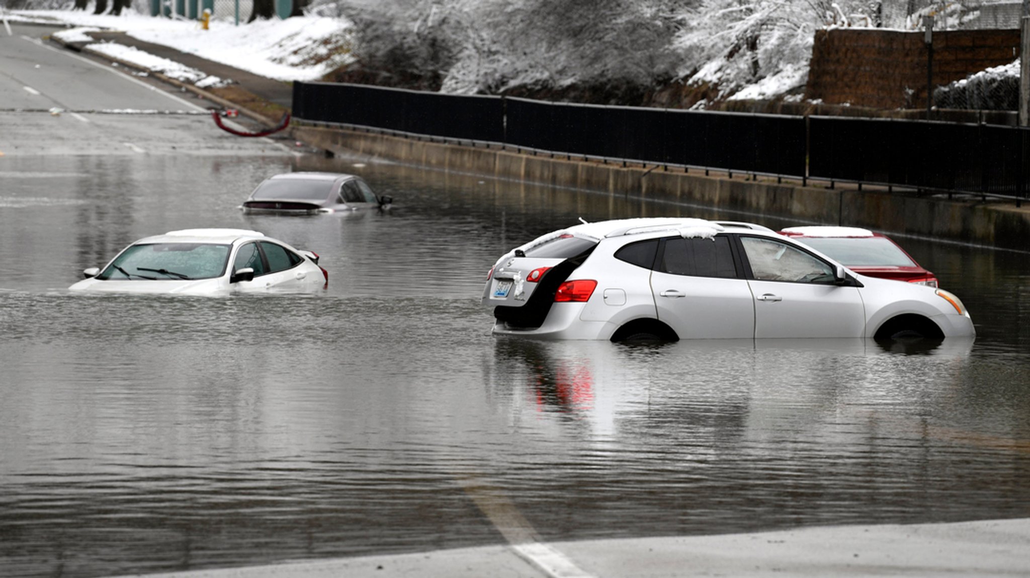 16.02.2025, USA, Louisville: Autos stehen im Hochwasser an einer Eisenbahnunterführung in Louisville. 