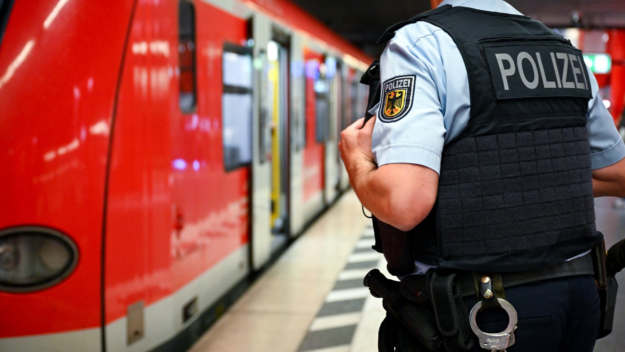 Ein Bundespolizist steht am Hauptbahnhof an einer S-Bahn.