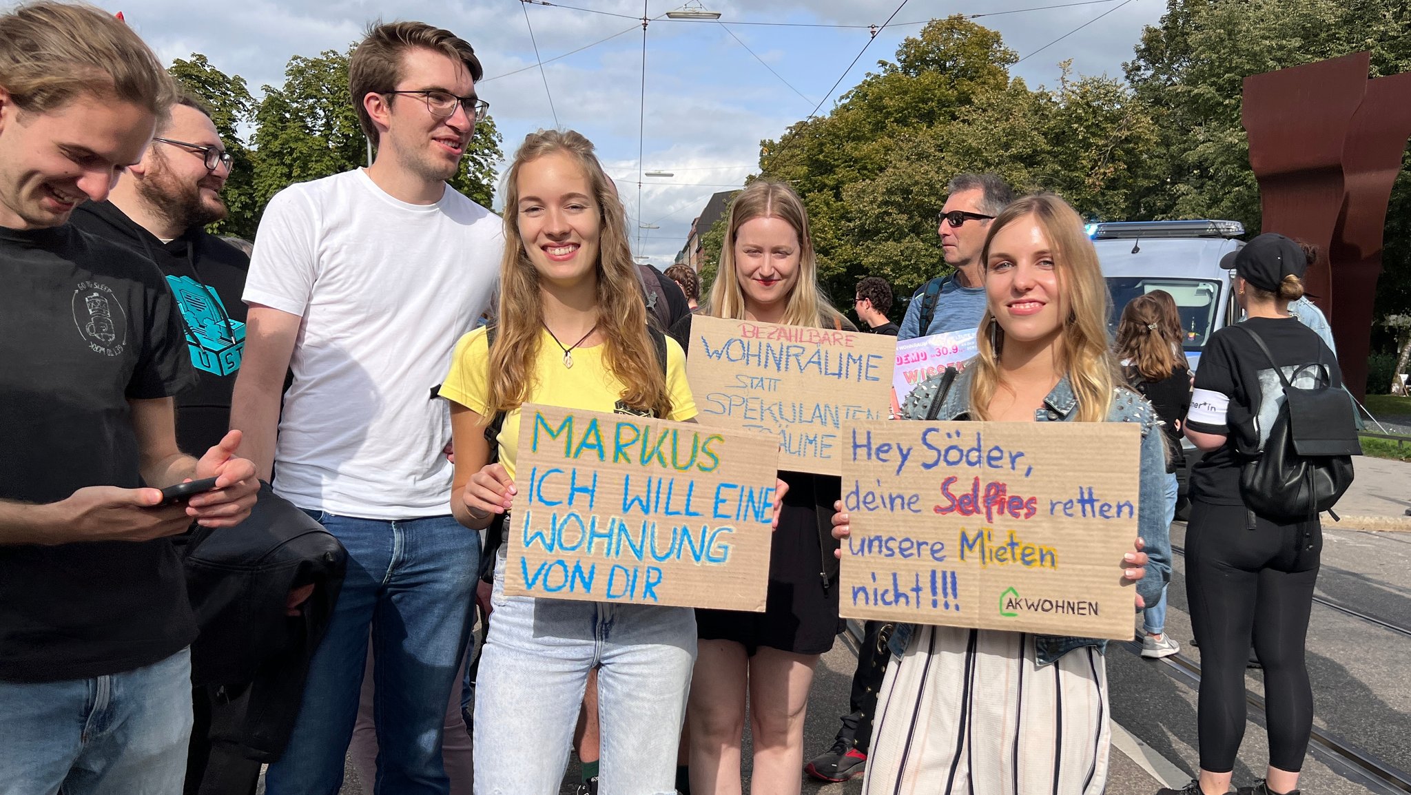 Junge Frauen halten Plakate mit Slogans für mehr bezahlbaren Wohnraum in den Händen.