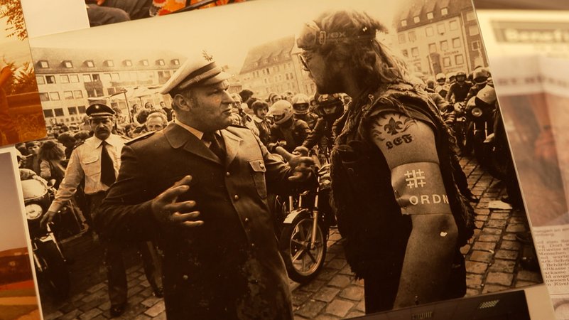 Ein Foto zeigt einen Polizisten zusammen mit einem Rocker. | Bild: BR Ein Foto zeigt einen Polizisten zusammen mit einem Rocker.
