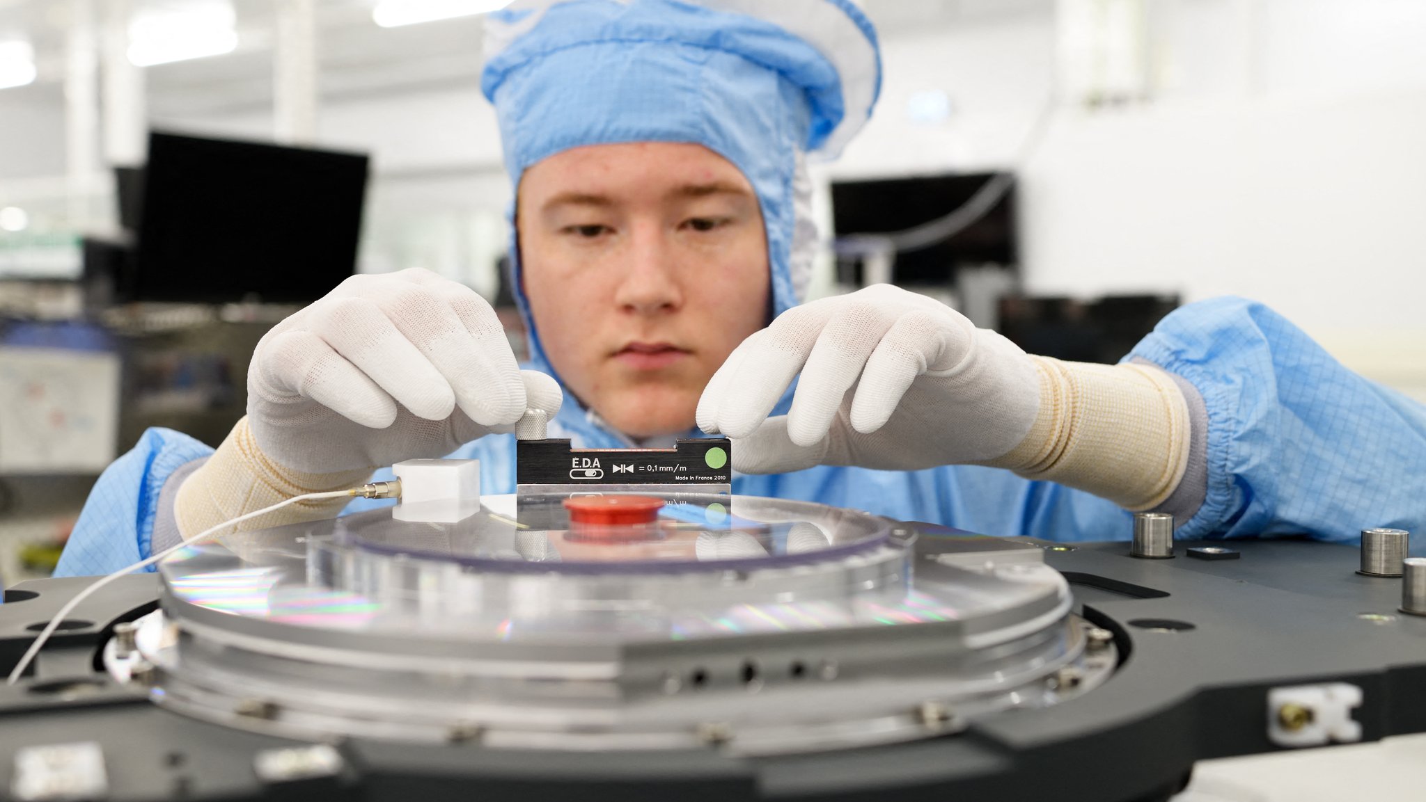 Ein Mitarbeiter der Firma ASML in Veldhoven arbeitet in einem Cleanroom an einem Werkstück