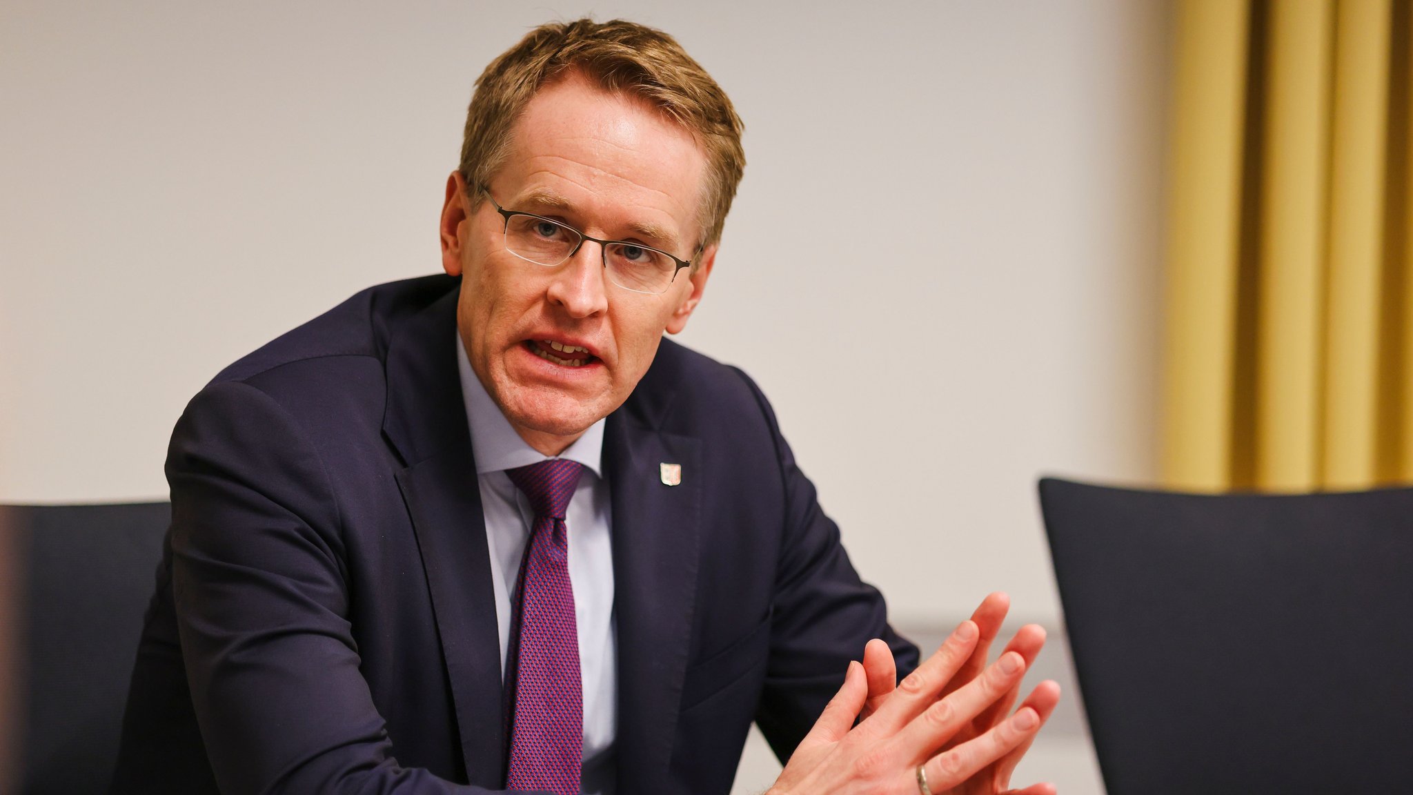 Daniel Günther sitzt an einem Tisch