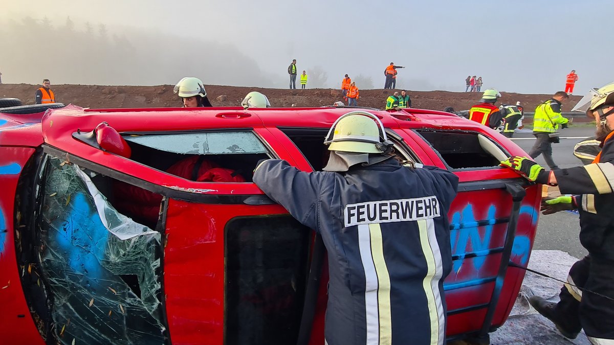 Feuerwehrleute machen sich an einem "verunfallten" Auto zu schaffen