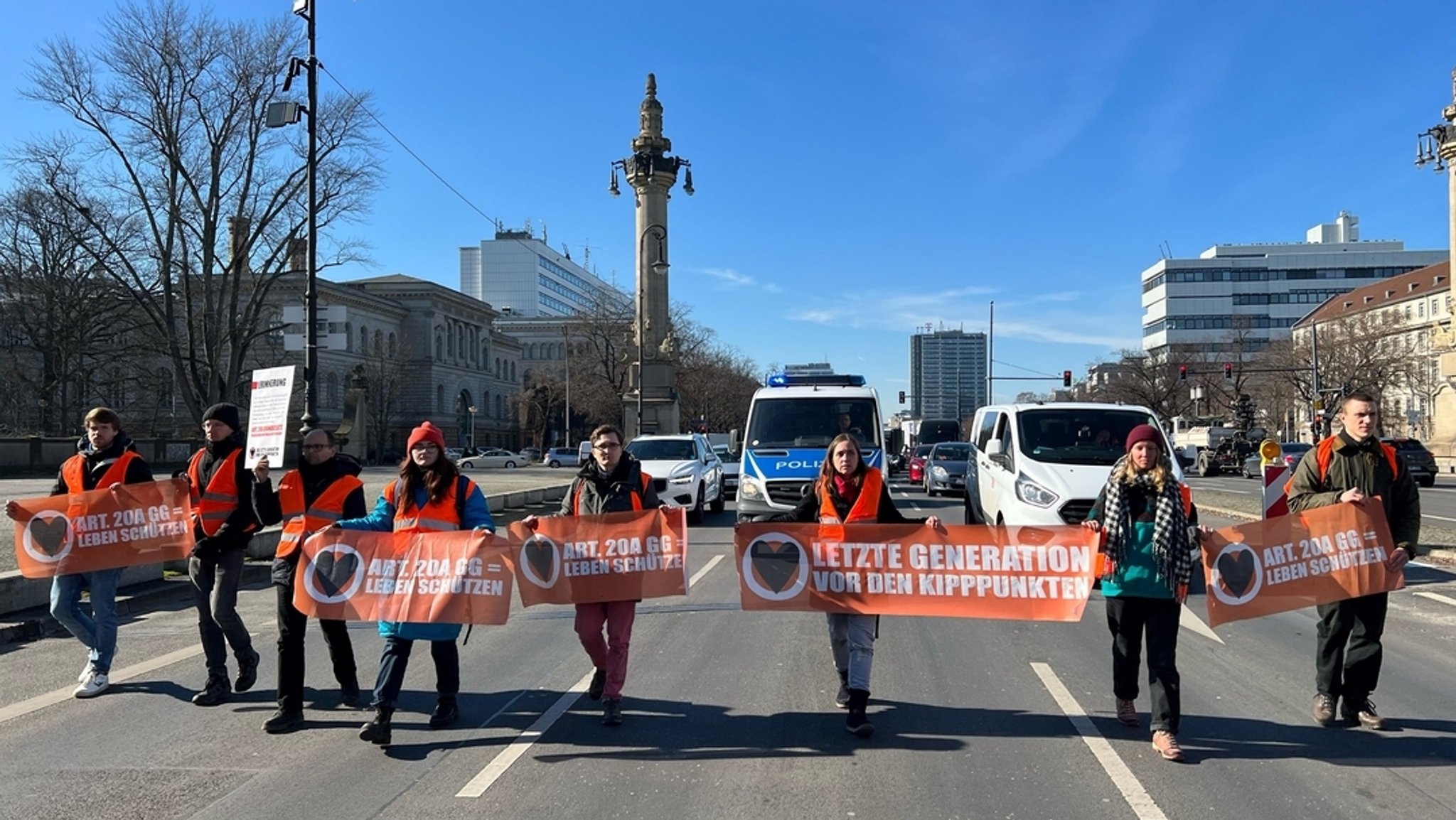 Klimaaktivisten der Gruppe "Letzte Generation" blockieren eine Straße vor dem Charlottenburger Tor in Berlin.