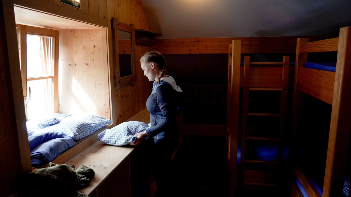 Pia Waltner steht zwischen Stockbetten in einer holzverkleideten Alpenvereinshütte. Es sind die letzten Vorbereitungen vor Eröffnung der Saison des Prinz-Luitpold-Hauses. 