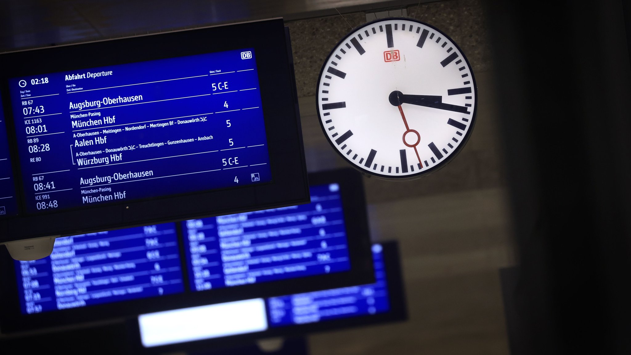(Symbolbild) Bildschirme zeigen die Abfahrtszeiten verschiedener Züge im Augsburger Hauptbahnhof.