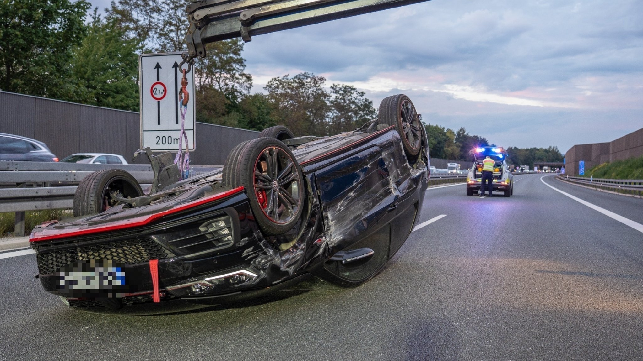 Ein Auto liegt auf dem Dach. Im Hintergrund ist ein Einsatzfahrzeug zu sehen. 