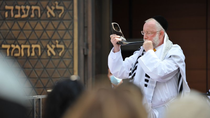 Rabbiner Shmuel Aharon bläst am St.-Jakobs-Platz vor der Ohel-Jakob-Synagoge in München das Schofar-Horn. | Bild: picture alliance / SZ Photo | Alessandra Schellnegger Rabbiner Shmuel Aharon bläst am St.-Jakobs-Platz vor der Ohel-Jakob-Synagoge in München das Schofar-Horn.