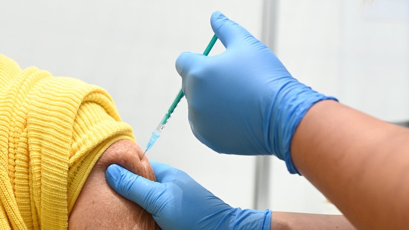 Einem Patienten wird gerade eine Impfdosis mit der Spritze verabreicht