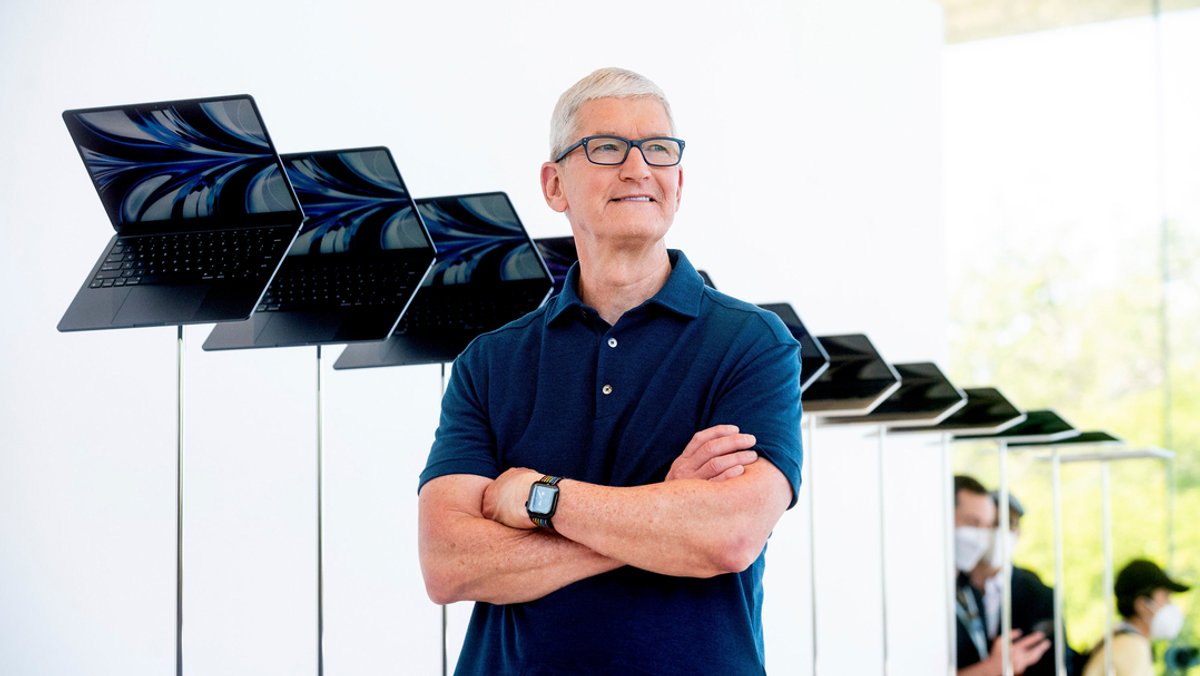 Apple-Chef Tim Cook vor einer Reihe von Notebooks.