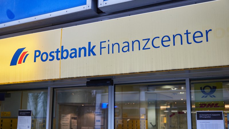 Die Aufschrift "Postbank Finanzcenter" steht über dem Eingang einer Postbankfiliale.