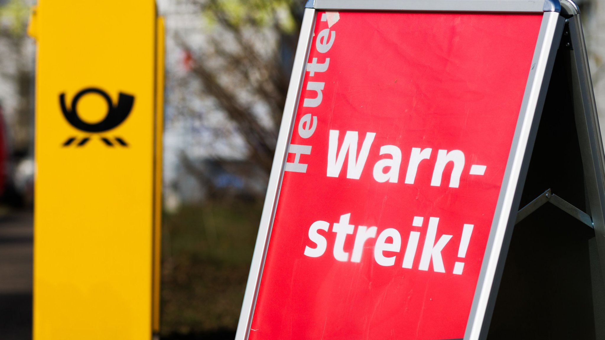 Ein Briefkasten, daneben ein Schild mit den Worten "Heute Warnstreik"