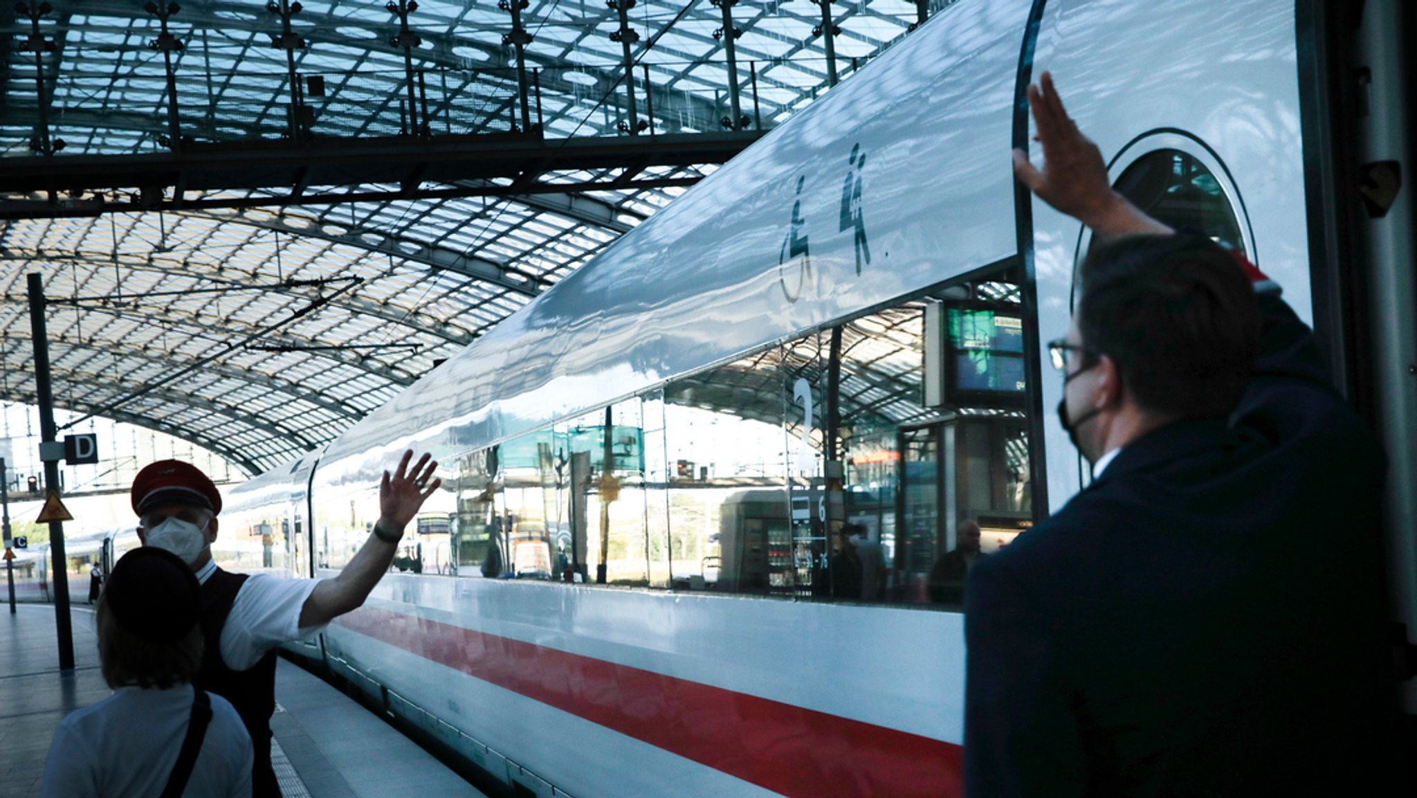 ARCHIV - 10.08.2021, Berlin: Ein Schaffner gibt ein Abfahrtszeichen für einen ICE auf dem Bahnsteig im Berliner Hauptbahnhof.