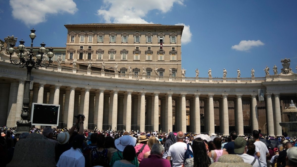 Menschen lauschen Papst Franziskus' Ansprache während des Mittagsgebets Regina Coeli vom Fenster seines Studios mit Blick auf den Petersplatz.