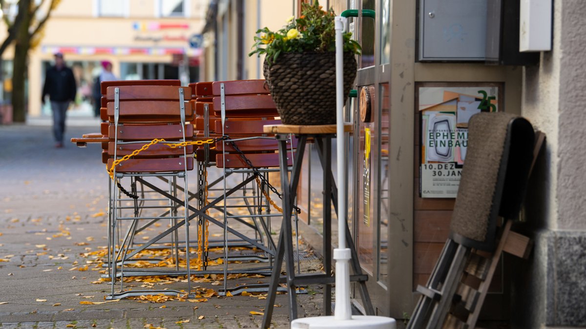 21.11.2021, Bayern, Bad Reichenhall: Tische und Stühle stehen vor einem Restaurant in der Innenstadt.