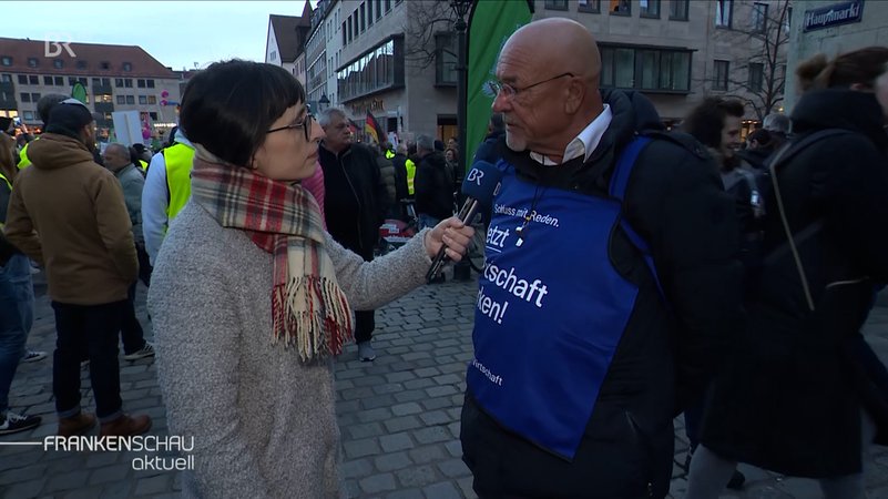 BR-Korrespondentin Tina Wenzel mit Interviewpartner auf dem Nürnberger Hauptmarkt.