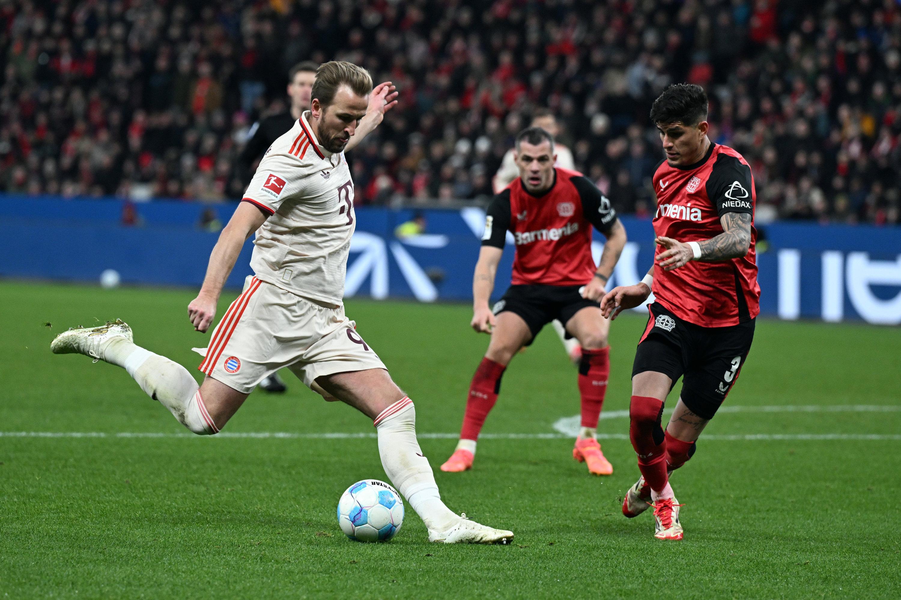 15.02.2025, Nordrhein-Westfalen, Leverkusen: Fußball: Bundesliga, Bayer Leverkusen - Bayern München, 22. Spieltag, BayArena, Leverkusens Piero Hincapie (r) und Bayerns Harry Kane kämpfen um den Ball. Foto: Federico Gambarini/dpa - WICHTIGER HINWEIS: Gemäß den Vorgaben der DFL Deutsche Fußball Liga bzw. des DFB Deutscher Fußball-Bund ist es untersagt, in dem Stadion und/oder vom Spiel angefertigte Fotoaufnahmen in Form von Sequenzbildern und/oder videoähnlichen Fotostrecken zu verwerten bzw. verwerten zu lassen. +++ dpa-Bildfunk +++