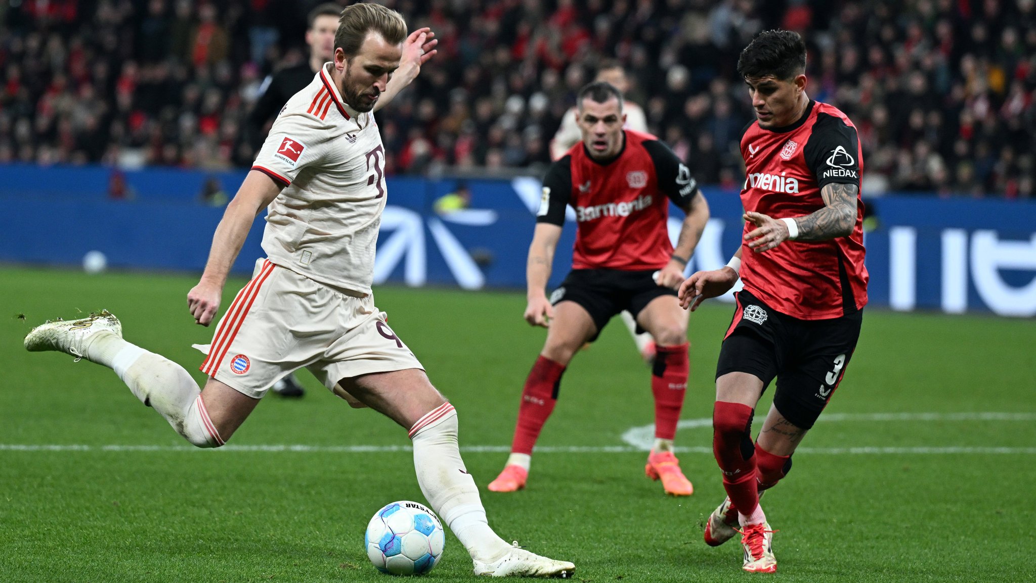 15.02.2025, Nordrhein-Westfalen, Leverkusen: Fußball: Bundesliga, Bayer Leverkusen - Bayern München, 22. Spieltag, BayArena, Leverkusens Piero Hincapie (r) und Bayerns Harry Kane kämpfen um den Ball. Foto: Federico Gambarini/dpa - WICHTIGER HINWEIS: Gemäß den Vorgaben der DFL Deutsche Fußball Liga bzw. des DFB Deutscher Fußball-Bund ist es untersagt, in dem Stadion und/oder vom Spiel angefertigte Fotoaufnahmen in Form von Sequenzbildern und/oder videoähnlichen Fotostrecken zu verwerten bzw. verwerten zu lassen. +++ dpa-Bildfunk +++