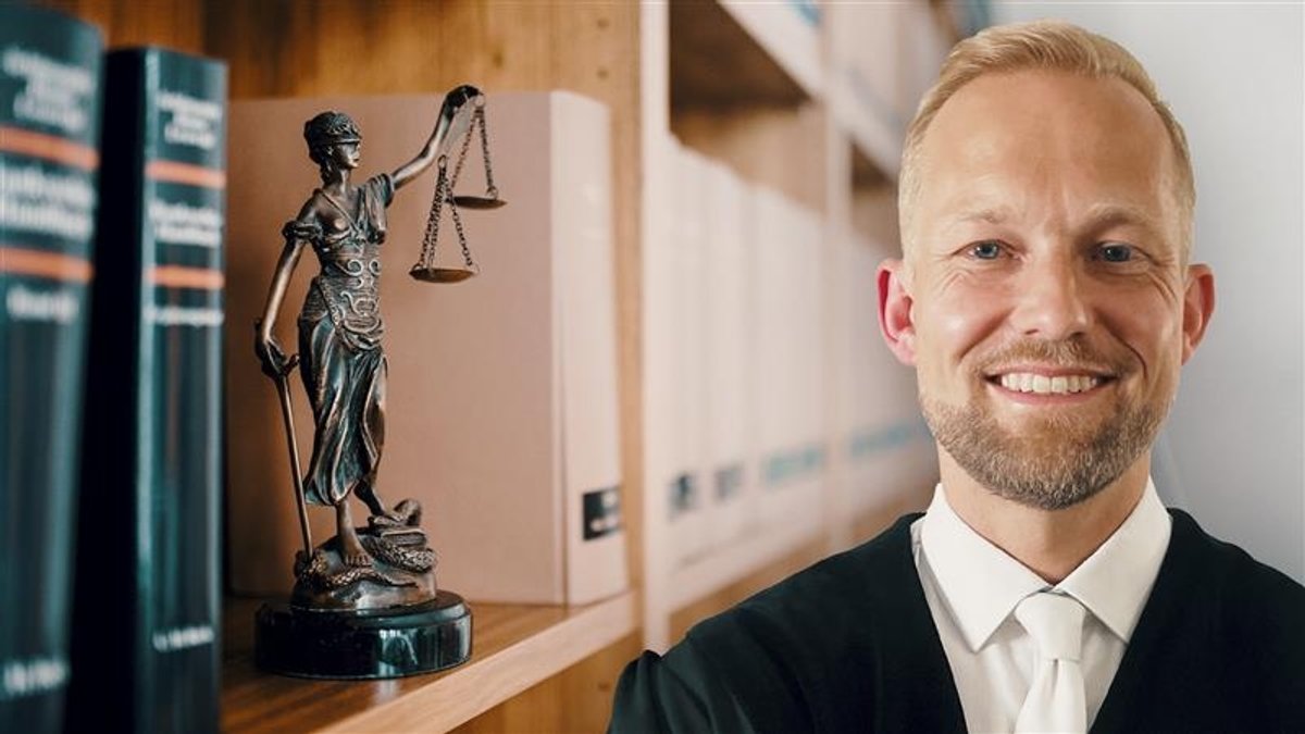 Richter Lorenz neben einer Justizia-Skulptur