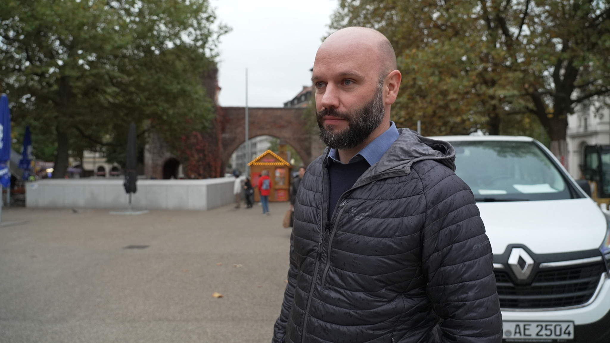 Ein Mann steht auf dem Sendlinger Tor-Platz. Im Hintergrund ist das Sendlinger Tor zu erkennen.