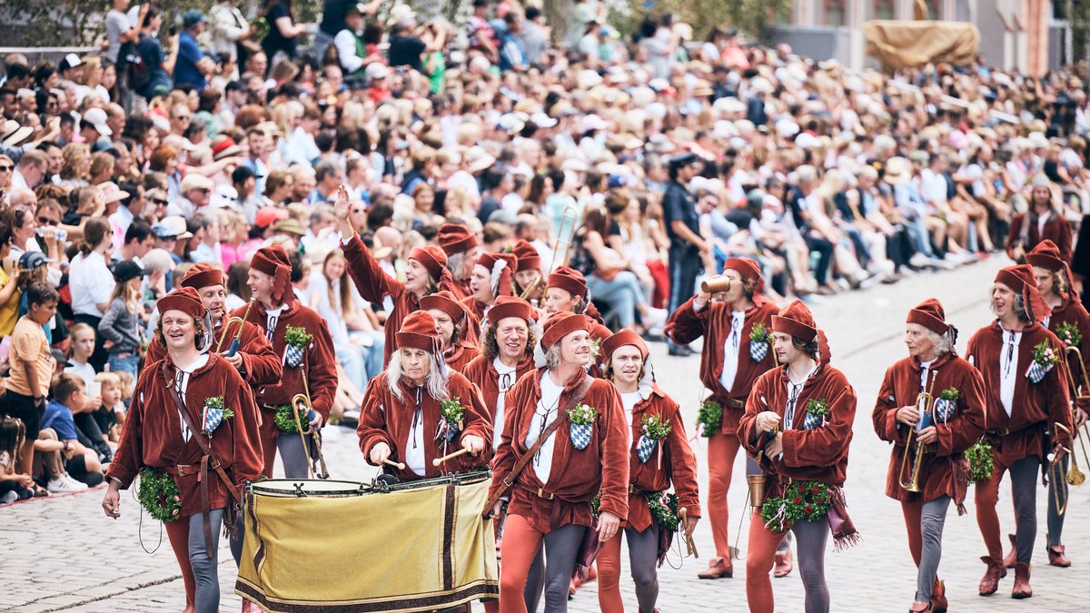 Der historische Festzug der "Landshuter Hochzeit" zieht durch die Stadt. Tausende Besucher jubeln dem Zug von Tribünen und dem Straßenrand zu.