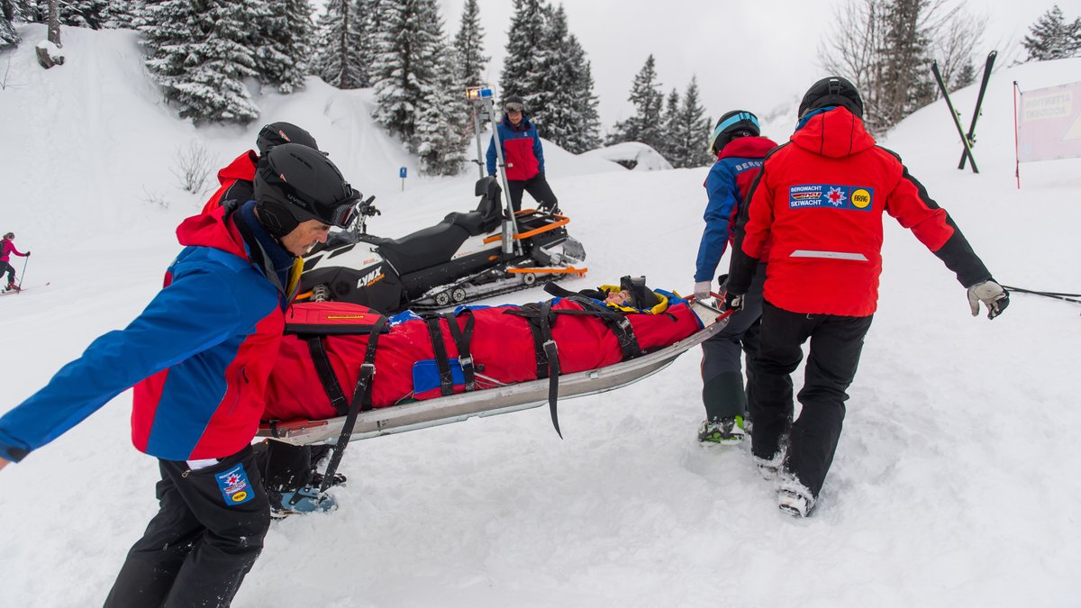 Mitglieder der Bergwacht helfen in einem Skigebiet in Garmisch-Partenkirchen einer verletzten Skifahrerin (gestellte Szene).