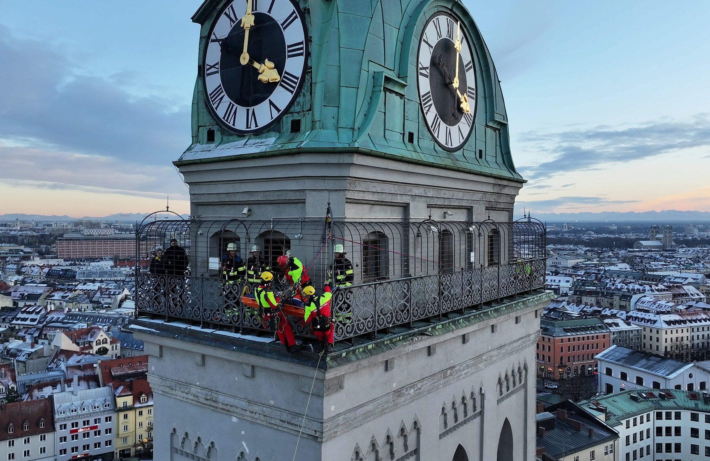  Kräfte der Berufsfeuerwehr München sind am Turm der Kirche St. Peter im Einsatz. Die Retter mussten eine verletzte Frau mit einer Seilrutsche aus gut 60 Metern Höhe nach unten bringen. 