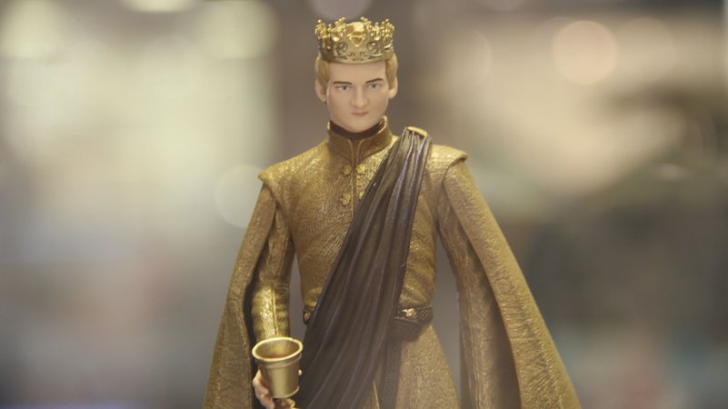 Eine Spielfigur von Joffrey Baratheon aus "Game of Thrones" mit Krone auf dem Kopf und goldenem Becher in der Hand vor unscharfem Hintergrund | Bild: picture alliance / Saxylosang/HPIC/dpa | Saxylosang Eine Spielfigur von Joffrey Baratheon aus "Game of Thrones" mit Krone auf dem Kopf und goldenem Becher in der Hand vor unscharfem Hintergrund