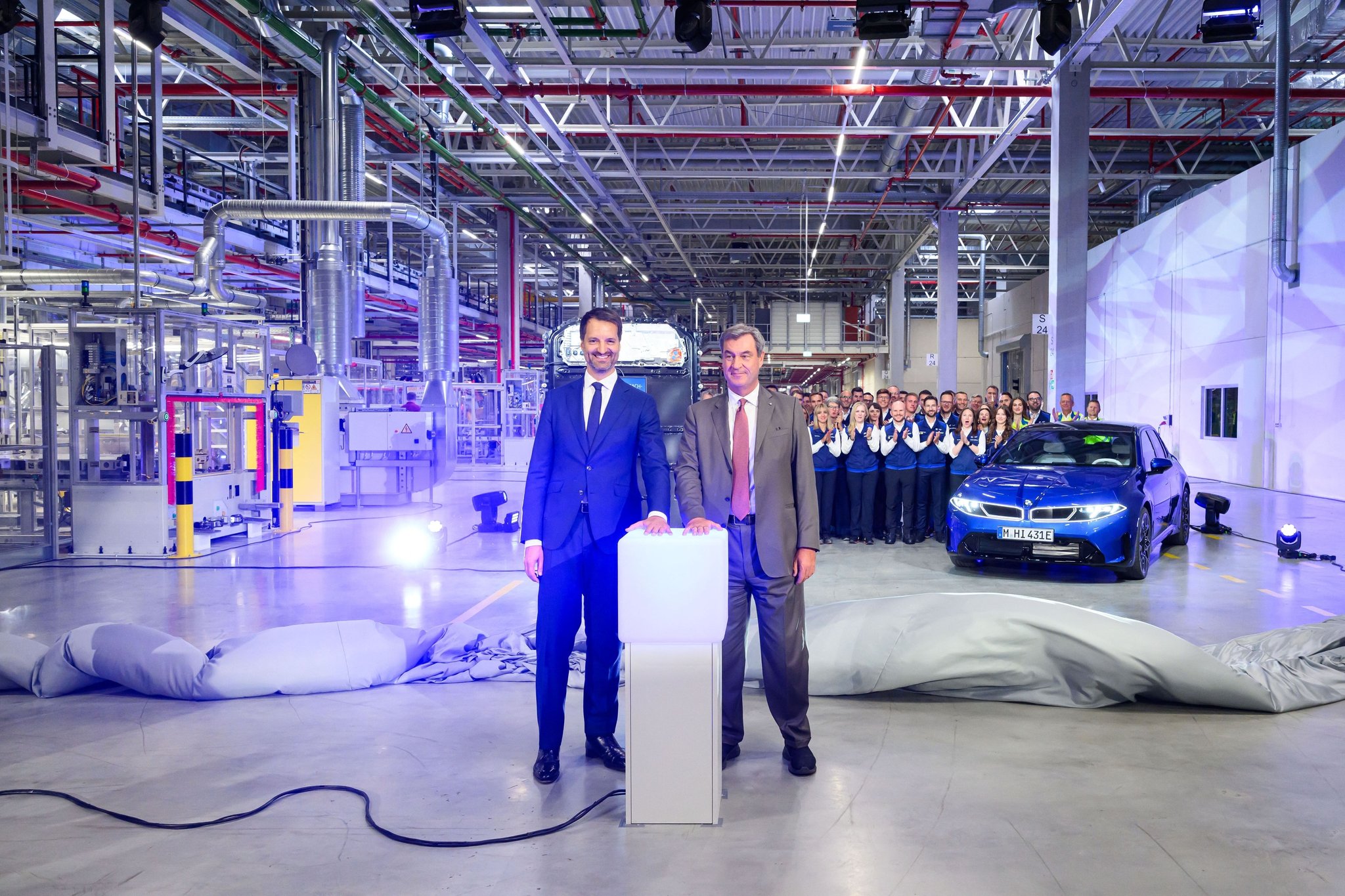 dpatopbilder - 01.10.2026, Bayern, Irlbach: BMW-Produktionsvorstand Raymond Wittmann und Bayerns Ministerpräsident Markus Söder (r) starten symbolisch den Produktionsbeginn im BMW-Batteriewerk Irlbach-Straßkirchen. Im Werk Irlbach-Straßkirchen werden Hochvoltbatterien für BMW-Elektro-Modelle hergestellt. Foto: Lukas Barth-Tuttas/dpa +++ dpa-Bildfunk +++