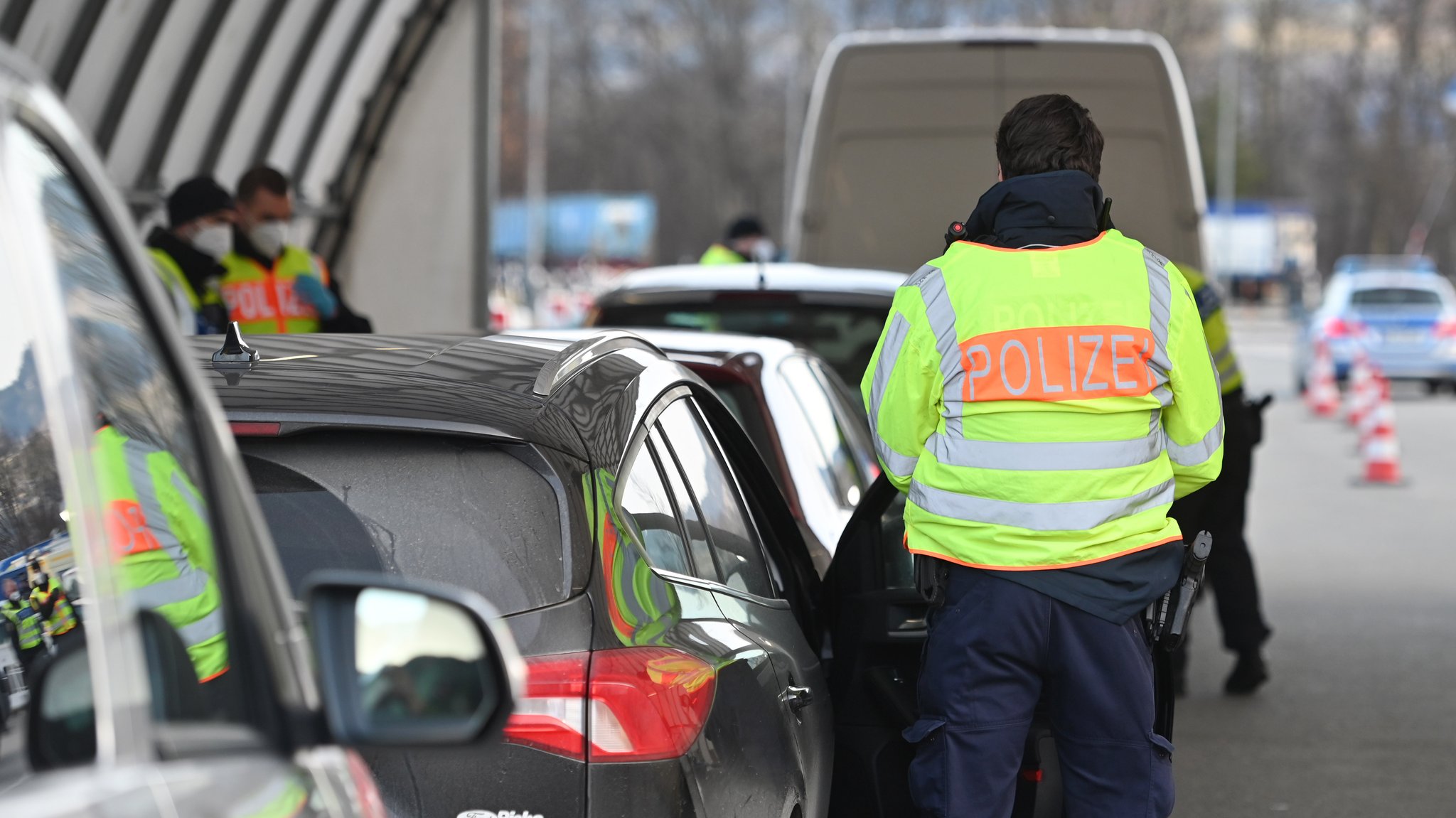 Polizisten stehen neben wartenden Autos während Grenzkontrollen