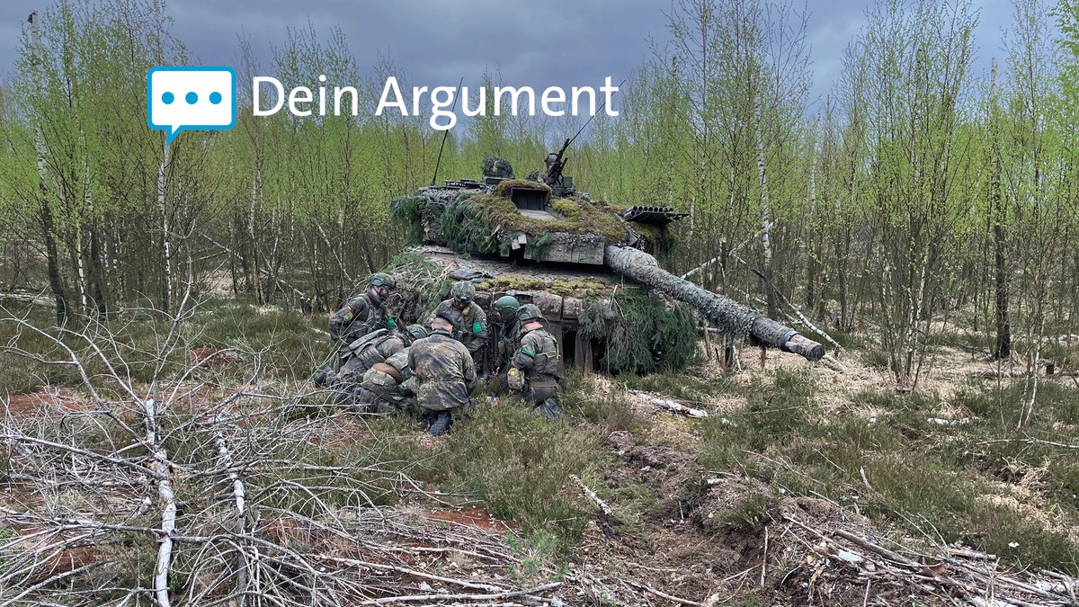 Soldaten der Bundeswehr beraten sich während eines Manövers vor einem Leopard-Panzer in Litauen.