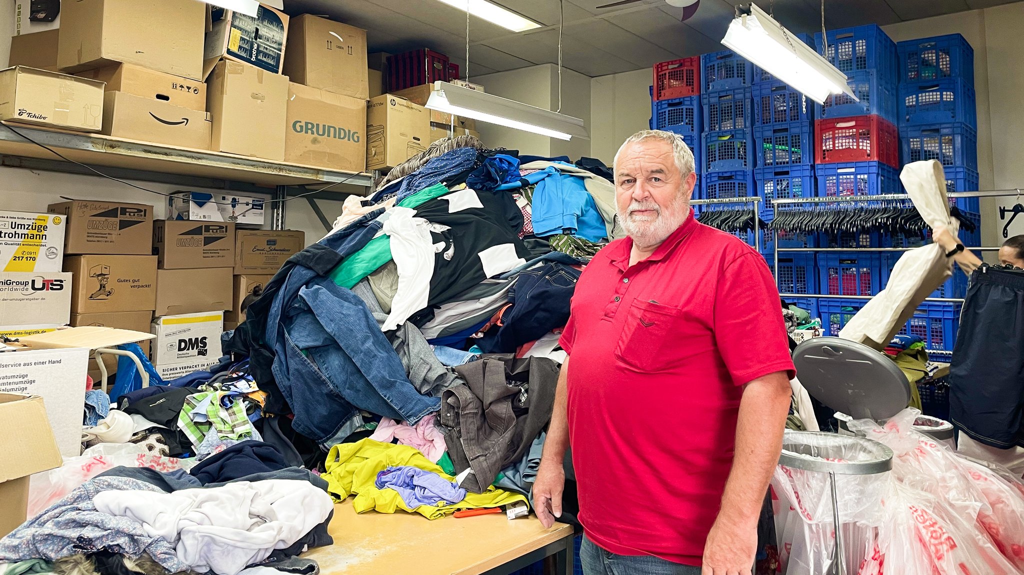 Helmut Huber am Sortiertisch beim BRK Nürnberg: Aus Bergen von Altkleidern wählt er die besten Teile für den Laden aus