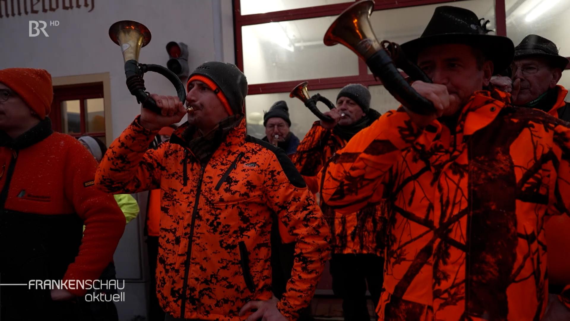 Jäger blassen nach der Jagd gemeinsam in Jagdhörner.