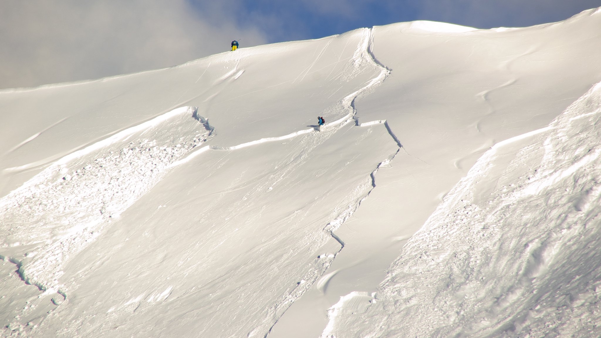 Eine Schneewand am Berg mit Rissen