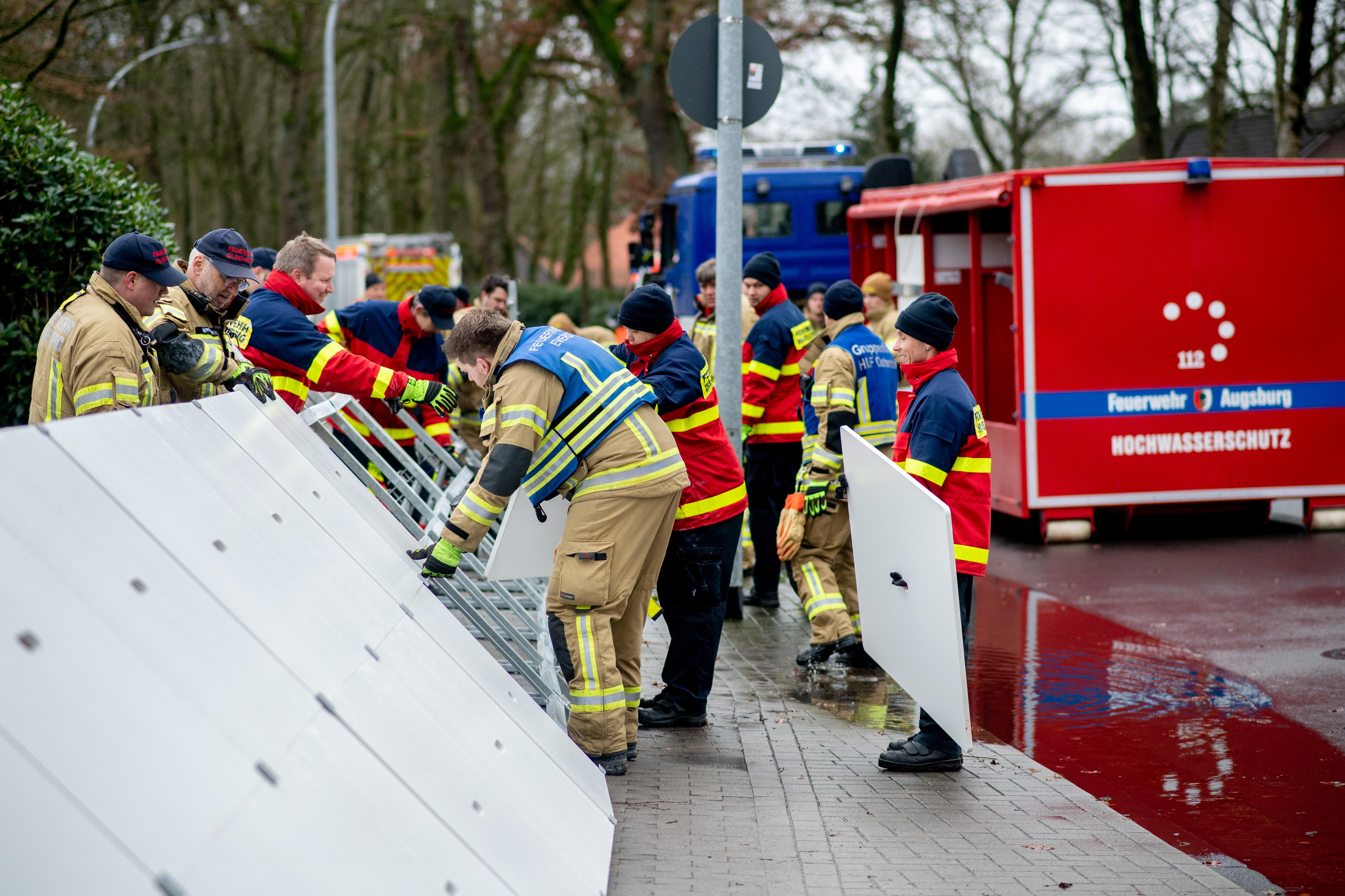 Niedersachsen, Oldenburg: Einsatzkräfte der Feuerwehr stellen einen mobilen Deich im Stadtteil Bümmerstede auf.