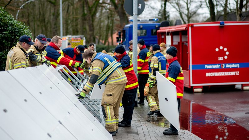 Niedersachsen, Oldenburg: Einsatzkräfte der Feuerwehr stellen einen mobilen Deich im Stadtteil Bümmerstede auf.