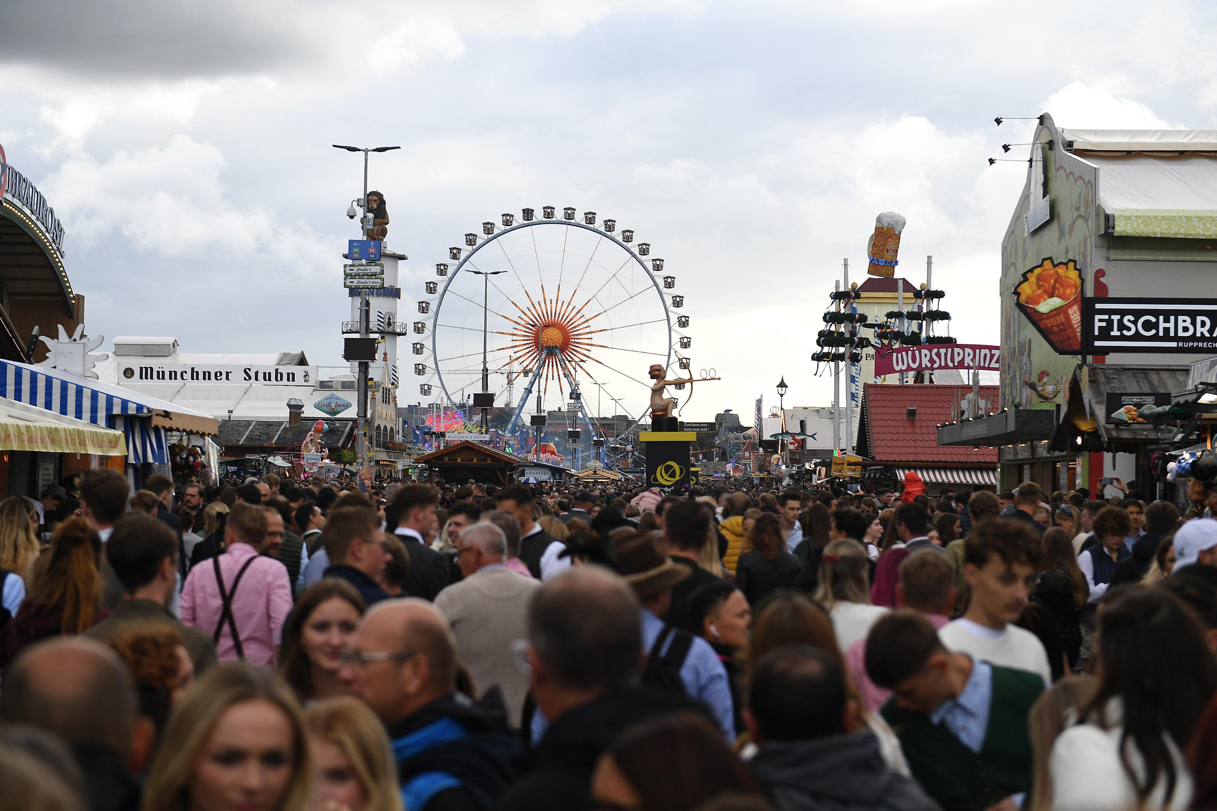 Dicht gedrängt gehen Gäste an einem regnerischen Tag über die Wiesn