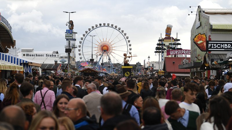 Dicht gedrängt gehen Gäste an einem regnerischen Tag über die Wiesn | Bild: picture alliance/dpa | Felix Hörhager Dicht gedrängt gehen Gäste an einem regnerischen Tag über die Wiesn