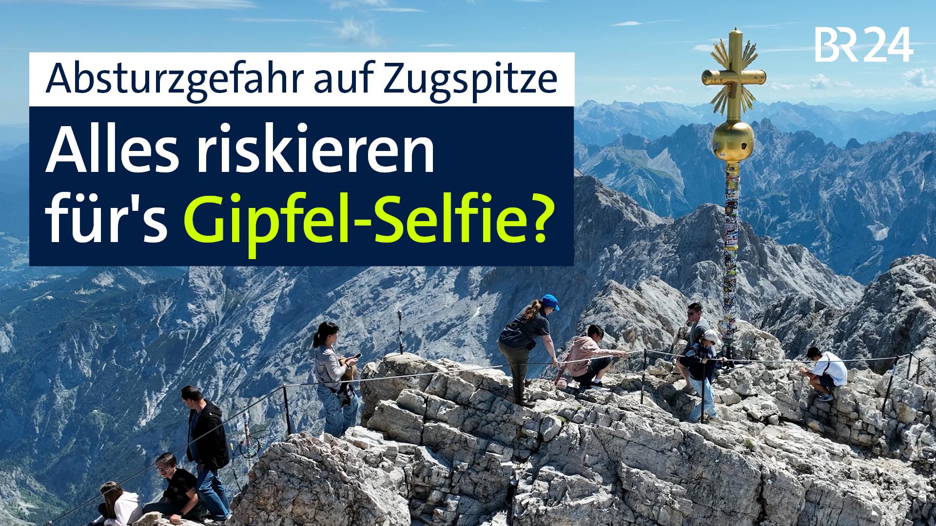 Touristen auf dem Weg zum Gipfelkreuz der Zugspitze.