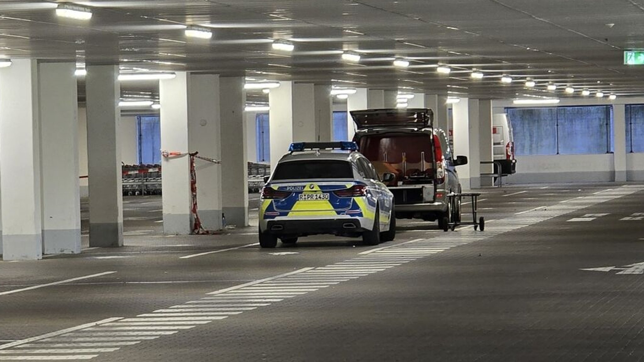 ARCHIV - 04.05.2024, Bayern, Regensburg: Einsatzkräfte der Kriminalpolizeiinspektion Regensburg arbeitet in einer Tiefgarage eines Baumarkts. Am Samstag in der Garage die Leiche einer Frau im Kofferraum eines Autos gefunden. Die Polizei ermittelt, wie die junge Frau aus dem Landkreis Cham ums Leben gekommen ist, so ein Sprecher. (zu dpa: «Tote 19-Jährige in Tiefgarage - Mordanklage erhoben») Foto: Moller-Schuh/vifogra/dpa +++ dpa-Bildfunk +++