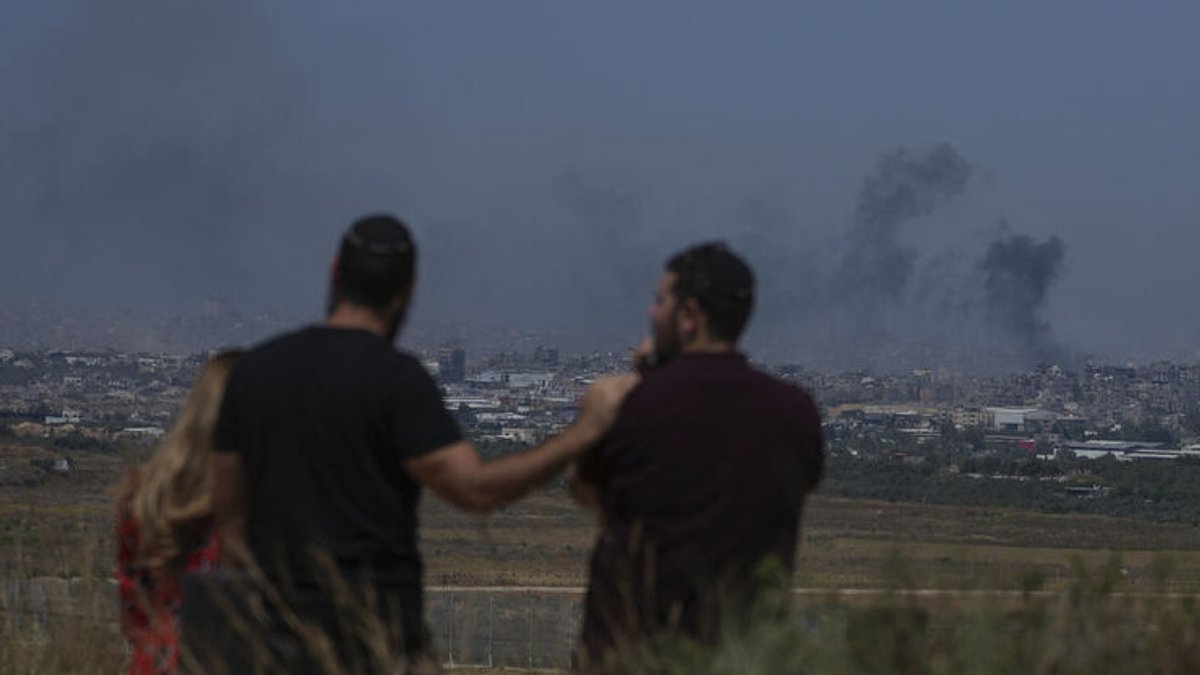 Menschen beobachten den Rauch, der nach einer Explosion im Gazastreifen in den Himmel steigt, vom Süden Israels aus gesehen. 