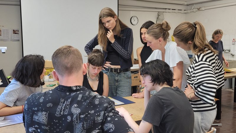 Eine Gruppe von acht Schülerinnen und Schülern steht und sitzt um einen Tisch herum auf dem Rechercherunterlagen aus dem Erinnerungsprojekt liegen. | Bild: Silke Bergau Eine Gruppe von acht Schülerinnen und Schülern steht und sitzt um einen Tisch herum auf dem Rechercherunterlagen aus dem Erinnerungsprojekt liegen.