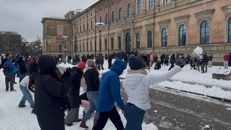 Personen nehmen an einer Schneeballschlacht vor der Alten Pinakothek in München teil. | Bild: picture alliance/dpa/Theo Miess | Theo Miess Personen nehmen an einer Schneeballschlacht vor der Alten Pinakothek in München teil.