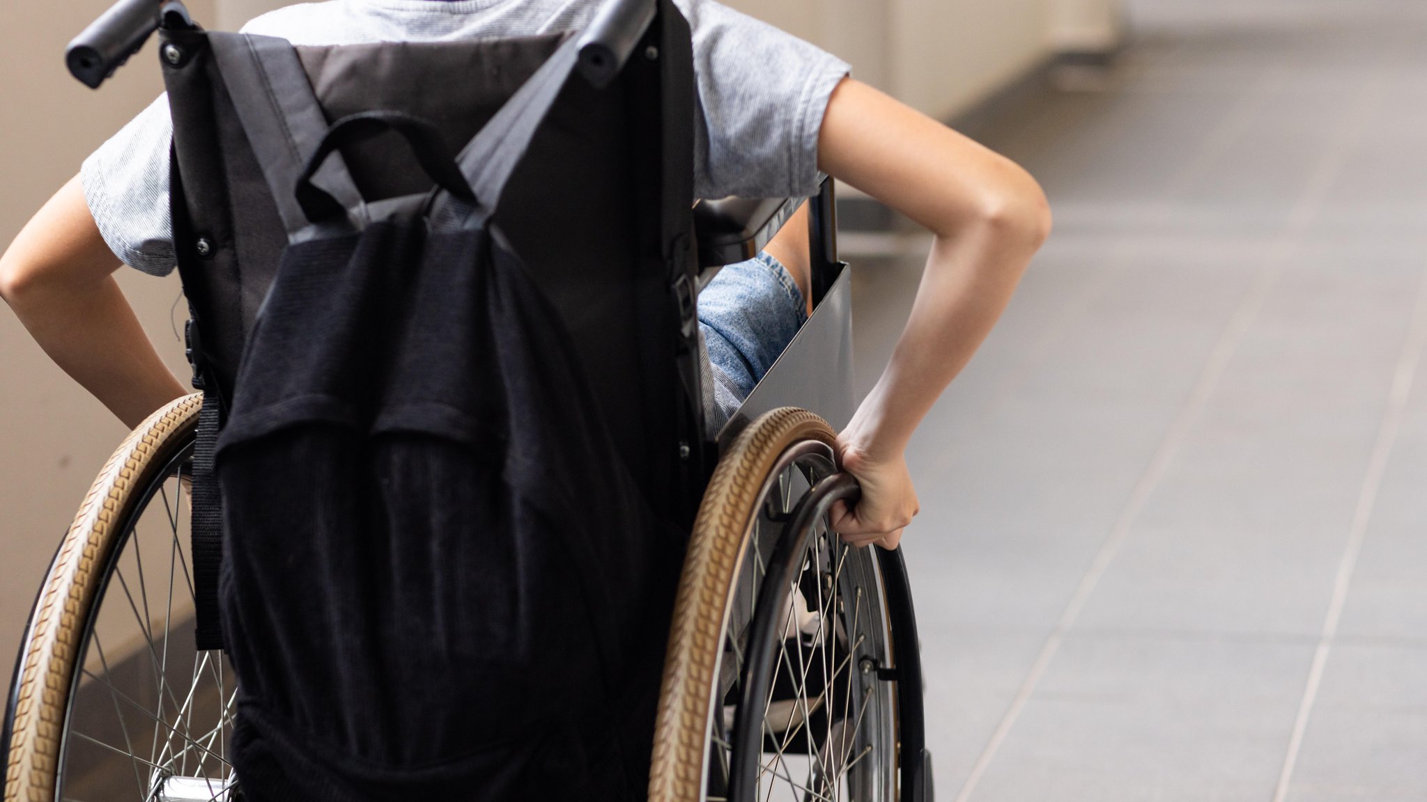 Ein Schüler fährt in einer Förderschule mit seinem Rollstuhl durch den Flur. (Symbolbild)