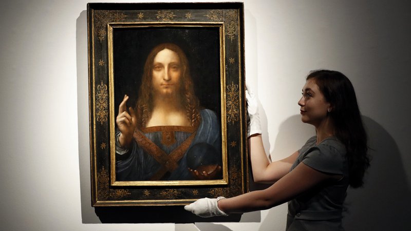 An employee poses with Leonardo da Vinci's "Salvator Mundi" on display at Christie's auction rooms in London.