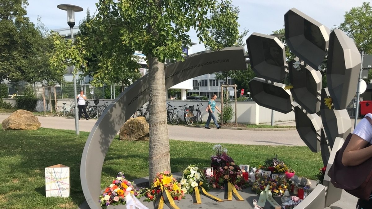 Trauernde vor dem Denkmal zum Gedenken an die Opfer des OEZ-Anschlags.
